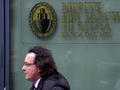 Un hombre camina por delante de una oficina del banco Monte dei Paschi en Siena.
