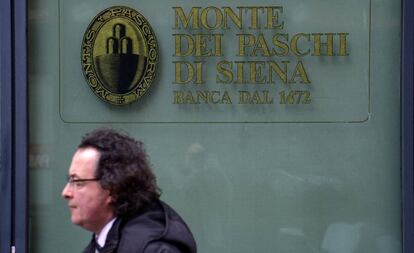 Un uomo passa davanti alla sede della Banca Monte dei Paschi a Siena.