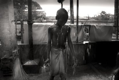 Un adolescente se ducha con el agua de la lluvia en el centro Nabulli Bon que alberga niños.