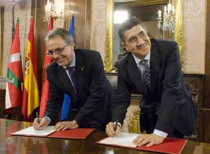 El presidente navarro, Miguel Sanz, y el <i>lehendakari,</i> Patxi López, firman un protocolo tras su reunión.