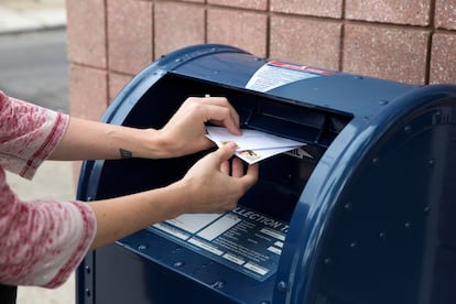 Una persona deposita cartas en un buzón del servicio postal en Filadelfia (Pensilvania) el 14 de agosto.