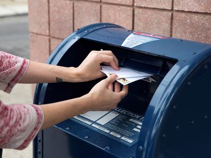 Una persona deposita cartas en un buzón del servicio postal en Filadelfia (Pensilvania) el 14 de agosto.