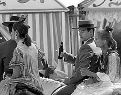 Dos parejas montadas a caballo durante la feria.