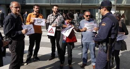 Un polic&iacute;a pide la identificaci&oacute;n a unas personas que protestaban por la detenci&oacute;n de menores en las manifestaciones estudiantiles.