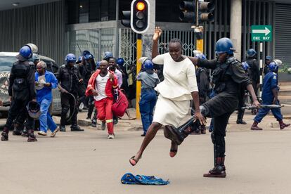 Un policía antidisturbios en Zimbabue da una patada a una mujer en una reunión convocada para escuchar un discurso del líder de la Alianza MDC (Movimiento para el Cambio Democrático), Nelson Chamisa, el 20 de noviembre.