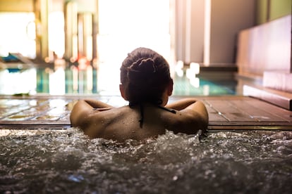 Una mujer se relaja en el interior de una piscina termal.