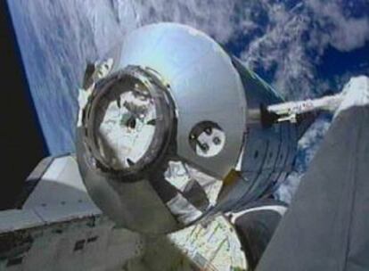 Un brazo mecánico teledirgido desde el <I>Discovery</I> durante la maniobra de acomplamiento del contenedor Leonardo a la ISS.
