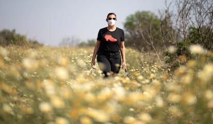 Una mujer con alergia camina por el campo protegida con una mascarilla, este lunes en Sevilla.