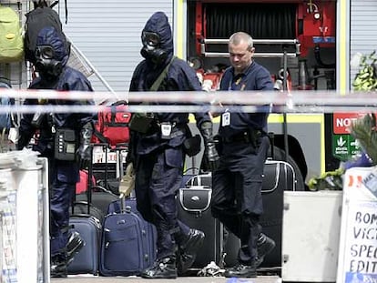 Varios policías con máscaras antigás entran en la estación de metro londinense de Warren Street.