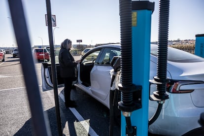 Una usuaria de coche eléctrico intenta cargar su vehículo en una estación de carga en Toledo.