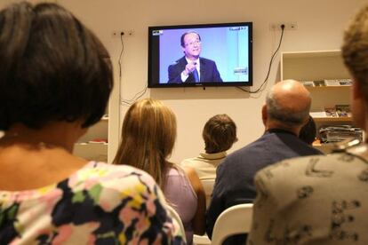 Un grupo de miembros del PS franc&eacute;s sigue el debate de primarias en Marsella. En la pantalla, el candidato Fran&ccedil;ois Hollande.