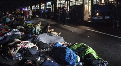 Policies vigilen refugiats que descansen a l'autopista en el seu camí cap a Budapest (Hongria), el 7 de setembre del 2015.