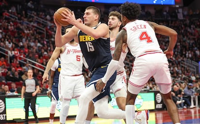 El pívot de los Denver Nuggets Nikola Jokić intenta encestar rodeado de jugadores de los Houston Rockets.