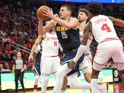 El pívot de los Denver Nuggets Nikola Jokić intenta encestar rodeado de jugadores de los Houston Rockets.