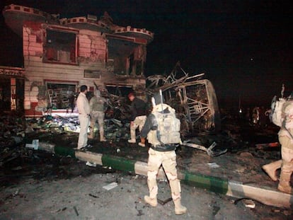 Fuerzas de seguridad iraqu&iacute;es en la gasolinera calcinada por el atentado, este jueves en Al Hala (Irak).