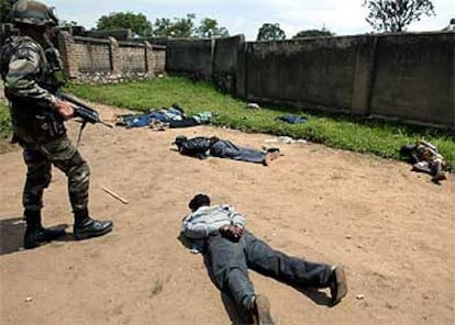 Un soldado francés vigila a varios pistoleros tras confiscarles sus armas ayer en Bunia.