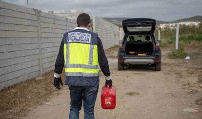 Un agente con un bidón de líquido inflamable, cerca del lugar de los hechos.