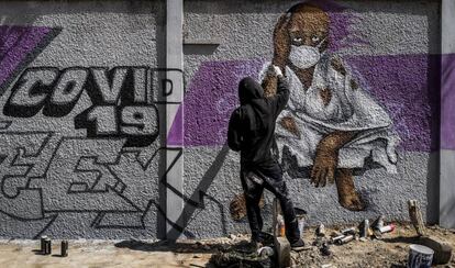 Un miembro del colectivo de graffiti senegalés RBS CREW pinta murales informativos para que los ciudadanos que no saben leer sepan cómo detener la propagación del coronavirus.