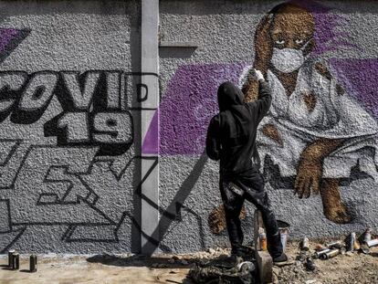 Un miembro del colectivo de graffiti senegalés RBS CREW pinta murales informativos para que los ciudadanos que no saben leer sepan cómo detener la propagación del coronavirus.