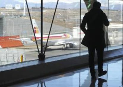 Un pasajero observa, un avión en el aeropuerto de Barajas en Madrid. EFE/Archivo