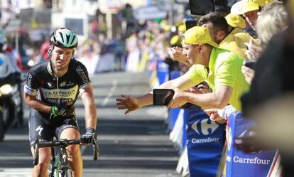 Mark Cavendish se sujeta el brazo derecho al cruzar la meta en Harrogate.