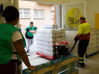 Voluntaris de l'organització El Gra de Blat, a Sants, descarreguen aliments.