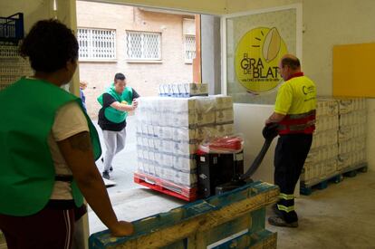 Voluntarios de la organización El Gra de Blat, en Sants, descargan alimentos. 