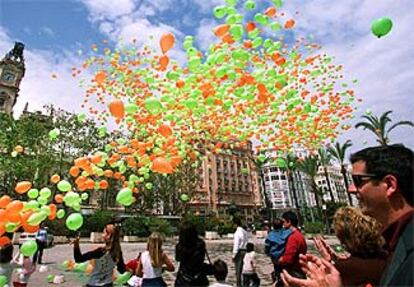 Cerca de 4.000 globos -exactamente 3.856, de acuerdo con el acta que levantó un notario- fueron soltados ayer en la plaza del Ayuntamiento de Valencia por los responsables y colaboradores de la Asociación Valenciana de Fibrosis Quística. El acto, similar a los celebrados en diversas ciudades españolas con motivo del Día Nacional de la Fibrosis Quística, pretendía llamar la atención a la ciudadanía acerca de esta enfermedad y recabar ayudas con el lema <i>Tú respiras sin pensar, yo no pienso más que en respirar. </i>En la imagen, el momento en que son soltados los globos, de colores verde y naranja, que son los que la asociación utiliza en su logotipo.