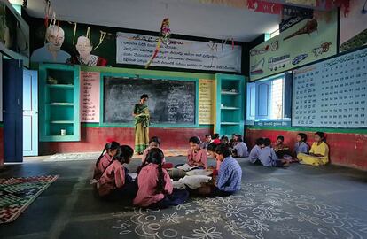 Niñas y niños estudian en una de las escuelas que la FVF tiene en Anantapur. Encima de la pizarra, la imagen de Vicente Ferrer y Ana Ferrer, que iniciaron esta fundación hace 40 años. 
