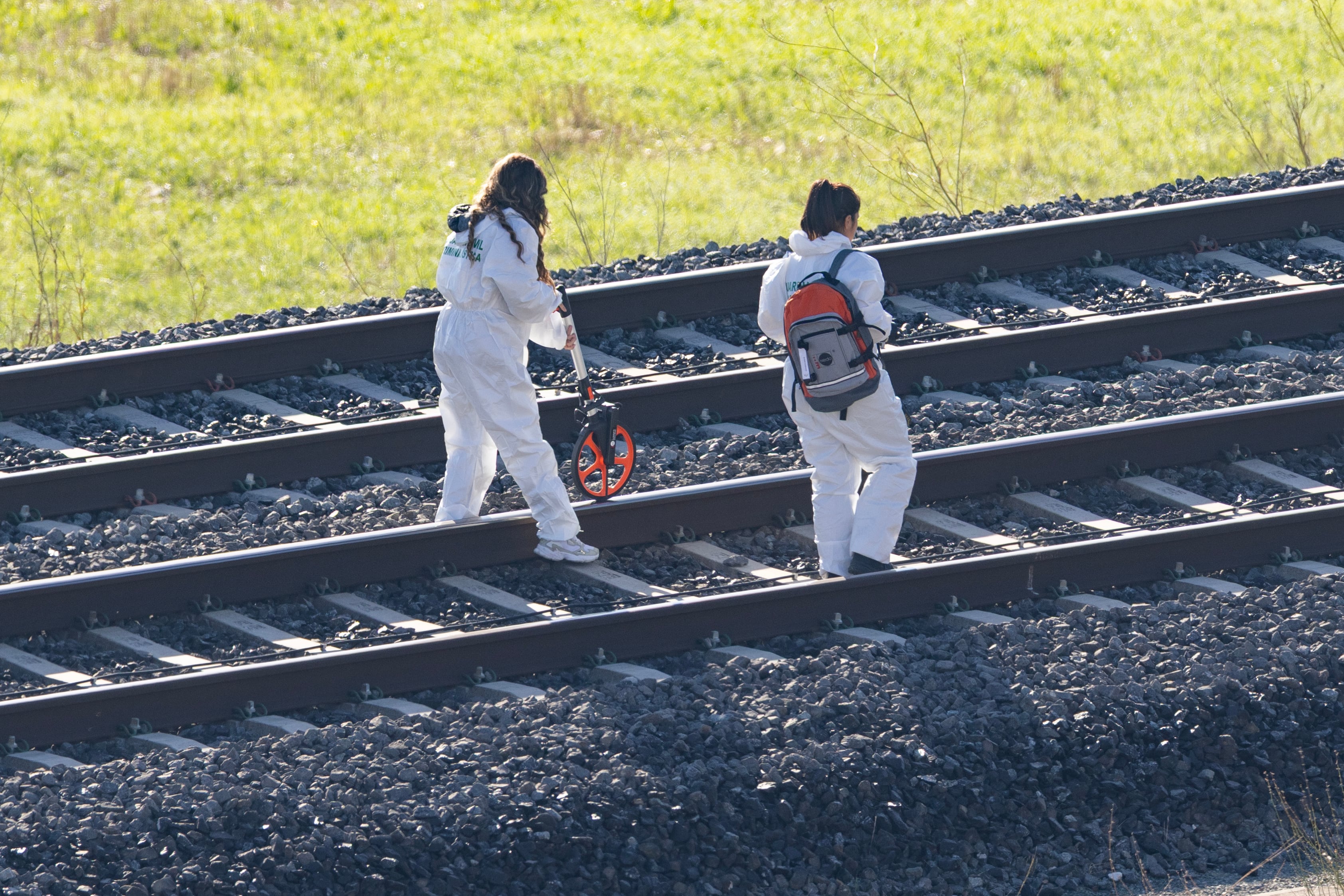 Fuerzas de seguridad investigan entre las vías de la línea de alta velocidad tras el accidente ferroviario ocurrido en Urda (Toledo), este jueves.