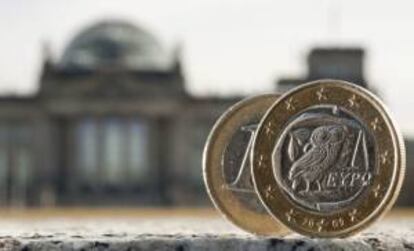 Dos monedas de euro, una de ellas acuñada en Grecia, fotografiadas delante del Bundestag en Berlín (Alemania). EFE/Archivo