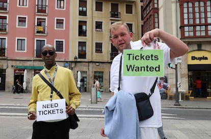 Aficionados ingleses portan carteles en Bilbao para conseguir entradas para la final europea.