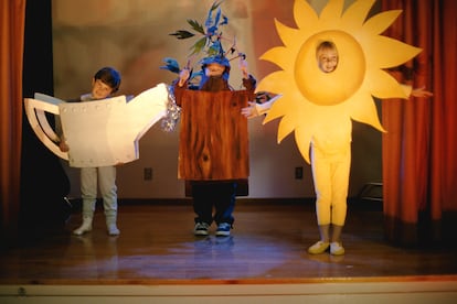 Tres menores participan en una representación teatral en un colegio.