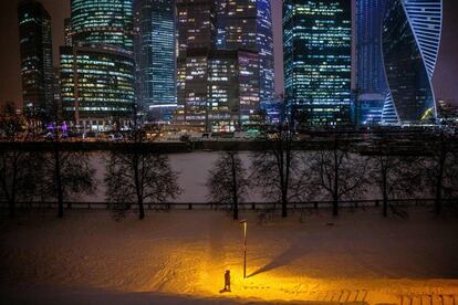 Un peatón camina por una calle cubierta de nieve cerca del río Moskva frente a los rascacielos del Centro Internacional de Negocios de Moscú. Rusia registró 17.525 nuevos casos de coronavirus, el máximo desde principios de mes, después de ocho días por debajo de la barrera de los 17.000 contagios, según el centro de lucha contra la pandemia del coronavirus.