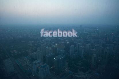 El logotipo de Facebook reflejado en una ventana del skyline de Beijing.