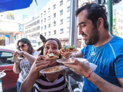 Una pareja comiendo una tostada de ceviche en el Caguamo (marisquería de calle).