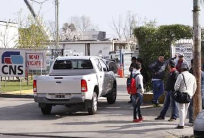 Operarios esperan frente al obrador del tren para su primer d&iacute;a de trabajo.