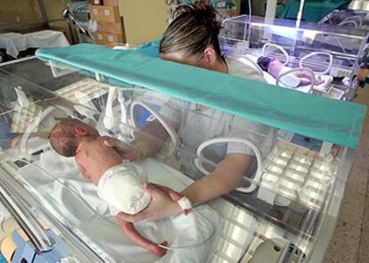 Una enfermera cambia de postura a un bebé en una de las incubadoras de la unidad de neonatología del hospital madrileño La Paz.