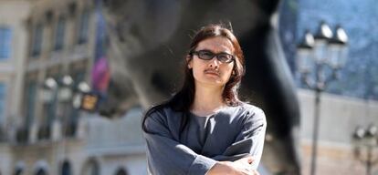 El artista de Taiwan Li Chen posa frente a una de sus estatuas en París
