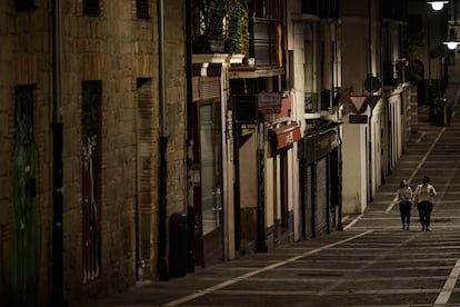 Residents wearing face mask walk along an empty street in Pamplona on October 24.