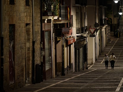 Residents wearing face mask walk along an empty street in Pamplona on October 24.