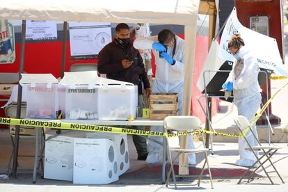 Técnicos forenses trabajan en una casilla electoral donde un hombre arrojó una cabeza humana, durante las elecciones en Tijuana.