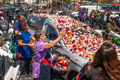 El recorrido avanzó hacia el cementerio Parque del Recuerdo en el municipio de Huechuraba, al norte de la ciudad, donde la familia realizará una ceremonia final íntima. Antes de su arribo al camposanto, la carroza ha sido llenada de pétalos de flores por parte de los trabajadores de la Pérgola de las Flores, cumpliendo con una tradición chilena de los funerales de personas de alta visibilidad pública. En la imagen, un grupo de floristas cubre la carroza fúnebre con pétalos de diferentes flores.