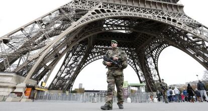 Un soldado monta guardia frente a la Torre Eiffel.