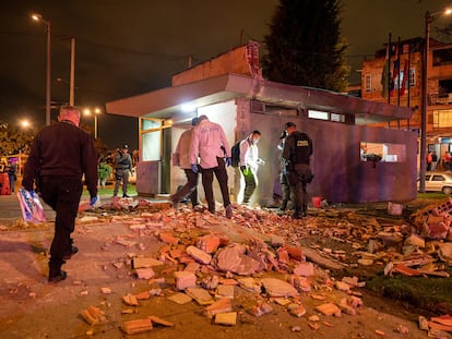 Autoridades y expertos en criminalística inspeccionan la estación de policía donde explotó un artefacto en Bogotá, este sábado.