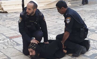 Agentes israelíes detienen a un monje copto que se manifestaba junto al Santo Sepulcro de Jerusalén, este miércoles.