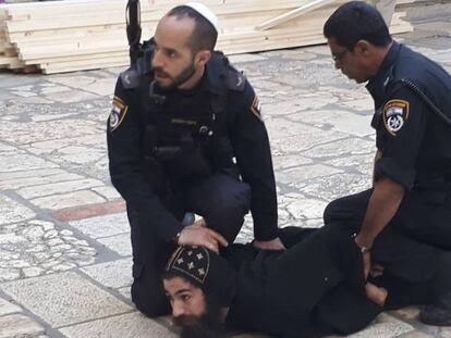 Agentes israelíes detienen a un monje copto que se manifestaba junto al Santo Sepulcro de Jerusalén, este miércoles.