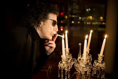 Charly García enciende un cigarrillo con la llama de una vela antes de una entrevista en Buenos Aires, Argentina, en 2013.