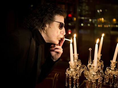 Charly García enciende un cigarrillo con la llama de una vela antes de una entrevista en Buenos Aires, Argentina, en 2013.