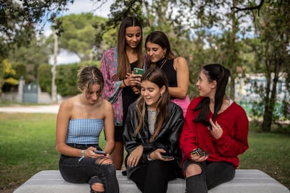 Las cinco amigas muestran sus teléfonos móviles y charlan sobre las publicaciones que ven en Instagram.